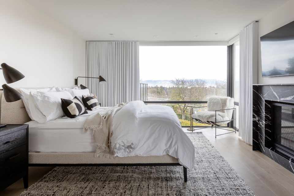 quiet luxury bedroom with neutral color palette and black marble fireplace